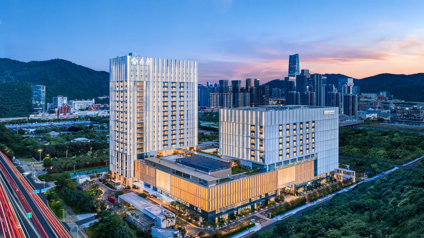 Shenzhen Qianhai Taikang Hospital and the surrounding Qianhai cityscape at dusk